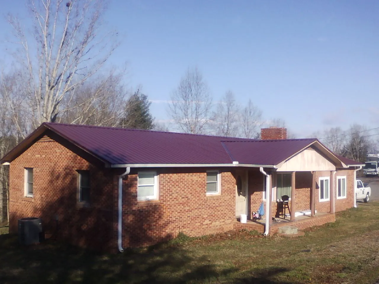 Burgundy metal roof on a brick ranch home with a new addition in Bellefontaine