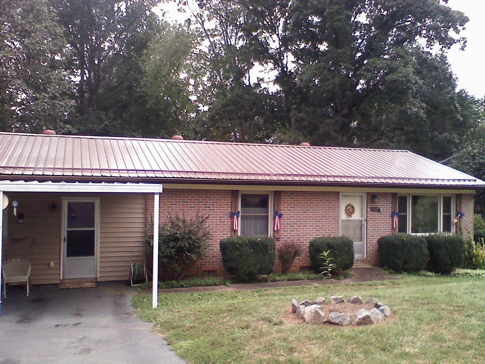Bronze metal roof and carport on a brick ranch home — Roof Repair work by our crew in Bellefontaine